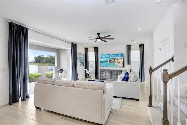 living room with ceiling fan and light hardwood / wood-style floors