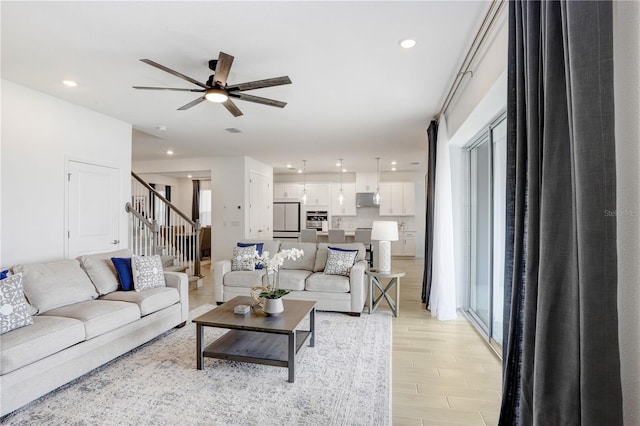 living room featuring ceiling fan, a healthy amount of sunlight, and light wood-type flooring