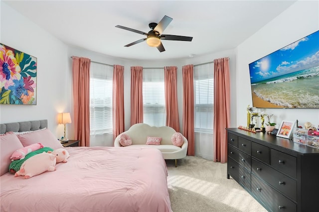 bedroom featuring light carpet, multiple windows, and ceiling fan