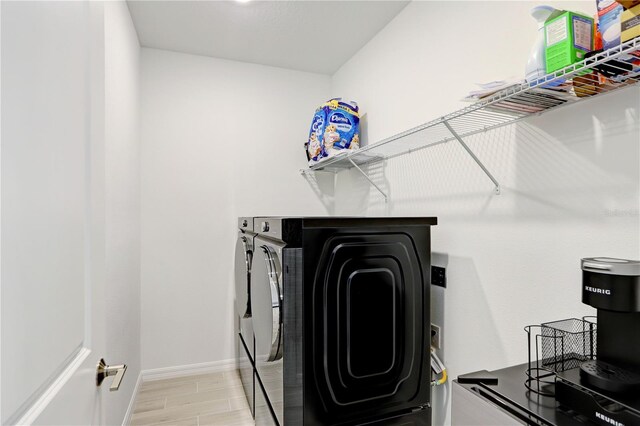 laundry area with light hardwood / wood-style flooring and washing machine and clothes dryer