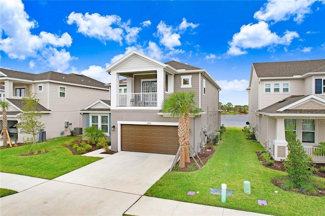 view of front facade with a front yard, a balcony, a garage, and a water view