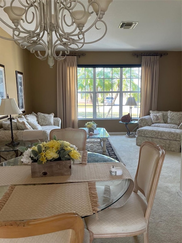 carpeted dining area featuring a chandelier