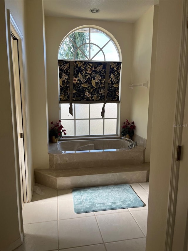 bathroom featuring a relaxing tiled tub and tile patterned floors