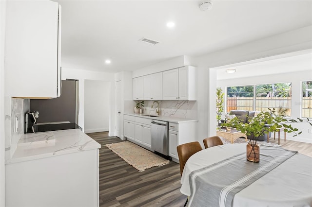 kitchen featuring sink, dark hardwood / wood-style floors, decorative backsplash, white cabinets, and appliances with stainless steel finishes