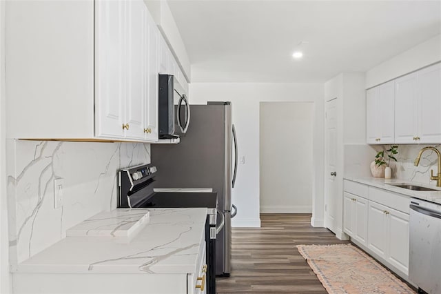 kitchen featuring sink, stainless steel appliances, light stone counters, dark hardwood / wood-style floors, and white cabinets