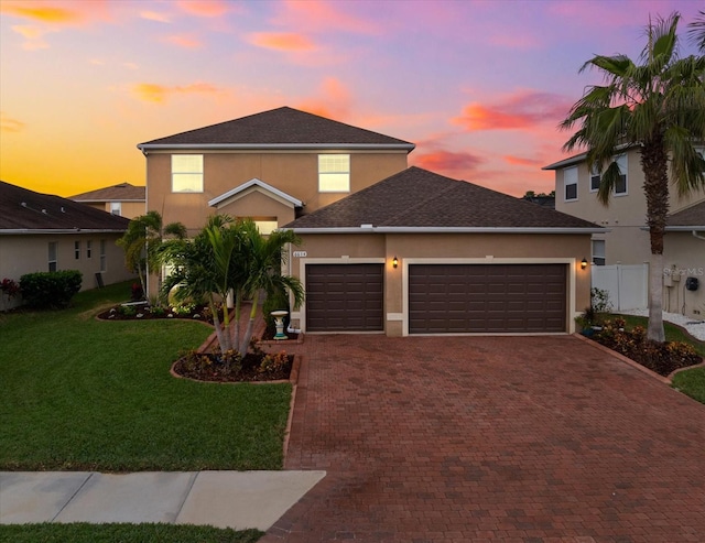 view of front of house with a garage and a lawn