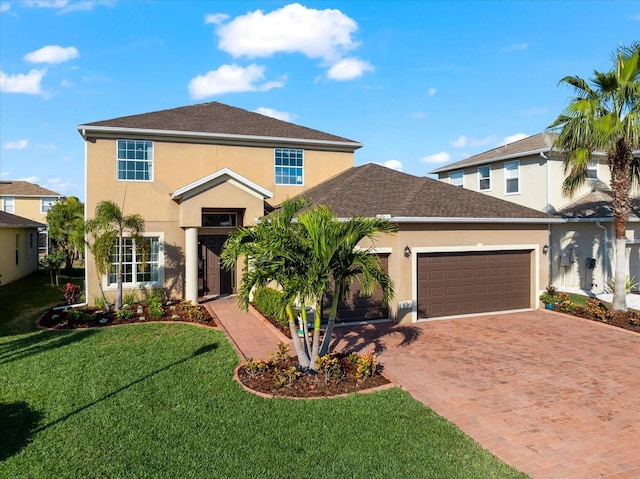 view of property with a garage and a front lawn