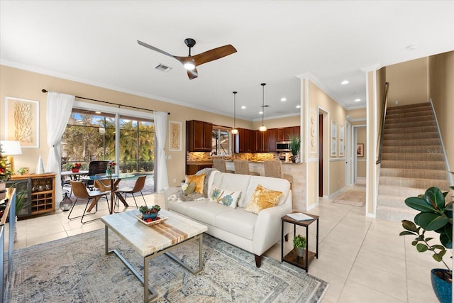 living room featuring light tile patterned floors, ornamental molding, and ceiling fan