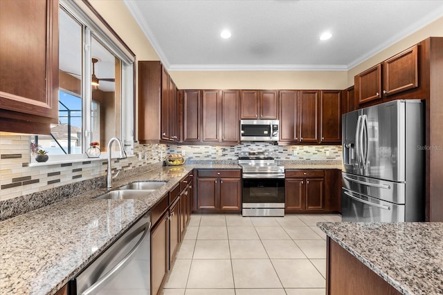 kitchen featuring sink, ornamental molding, light tile patterned floors, light stone counters, and stainless steel appliances