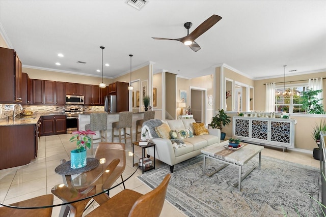 tiled living room with crown molding, sink, and ceiling fan with notable chandelier