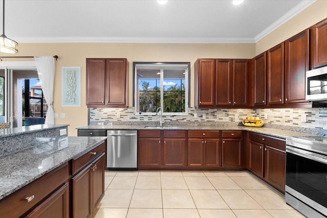 kitchen featuring sink, appliances with stainless steel finishes, hanging light fixtures, light stone counters, and ornamental molding