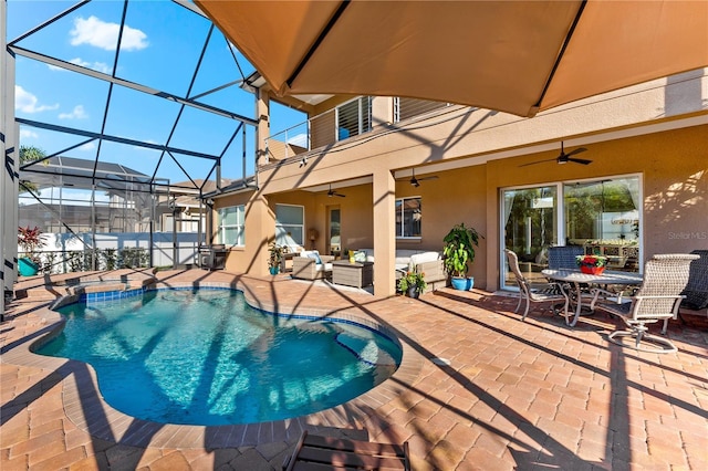 view of pool with glass enclosure, an in ground hot tub, ceiling fan, an outdoor living space, and a patio