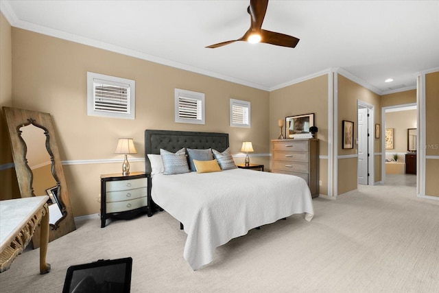 carpeted bedroom featuring crown molding, ceiling fan, and ensuite bath