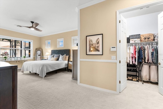 carpeted bedroom with crown molding, ceiling fan, and a closet