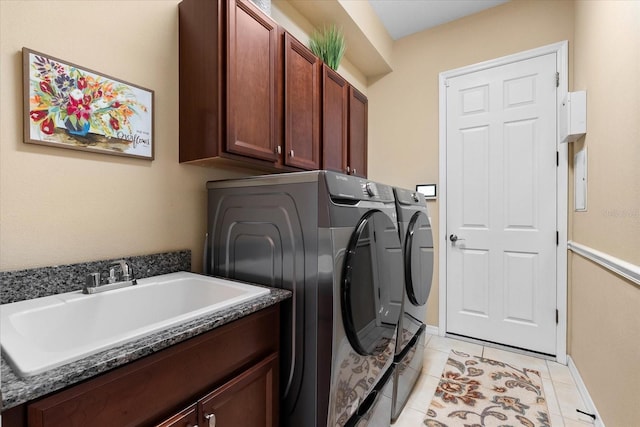 clothes washing area featuring cabinets, independent washer and dryer, sink, and light tile patterned floors