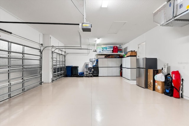 garage featuring a garage door opener and stainless steel refrigerator