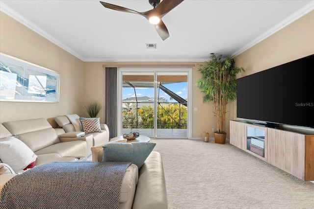 carpeted living room featuring ornamental molding and ceiling fan