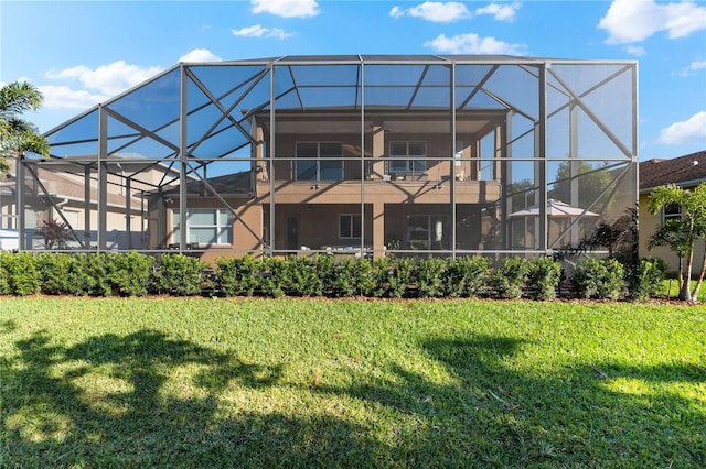 back of house with glass enclosure and a lawn