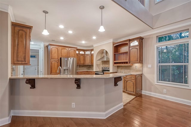 kitchen featuring a breakfast bar, stainless steel appliances, light hardwood / wood-style flooring, and light stone counters