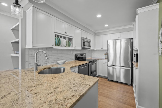 kitchen with white cabinetry, hanging light fixtures, stainless steel appliances, and sink