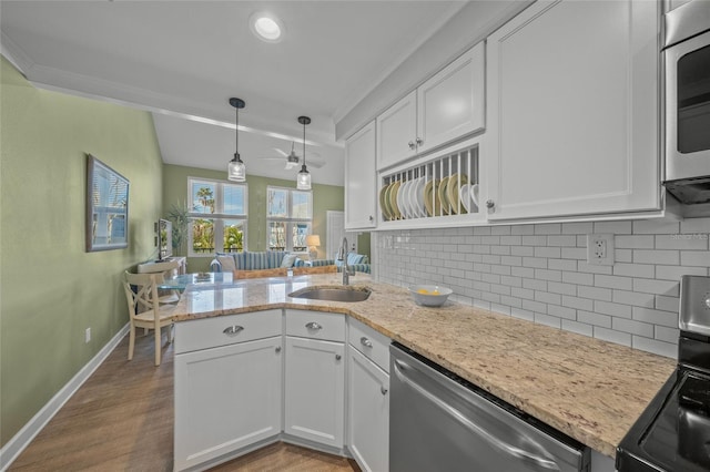 kitchen with sink, kitchen peninsula, light hardwood / wood-style flooring, appliances with stainless steel finishes, and white cabinetry