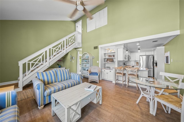 living room with ceiling fan, hardwood / wood-style floors, and high vaulted ceiling