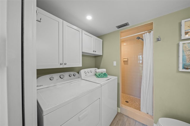 washroom featuring cabinets, light wood-type flooring, and independent washer and dryer