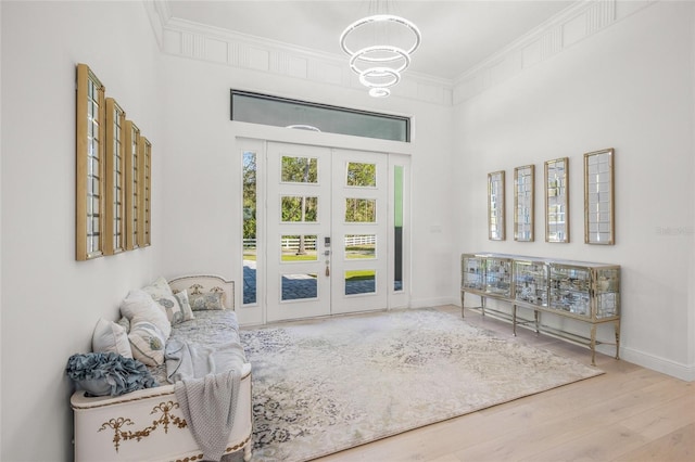 interior space featuring light wood-type flooring, crown molding, and french doors