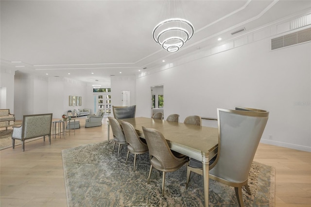 dining room with crown molding, french doors, and light wood-type flooring