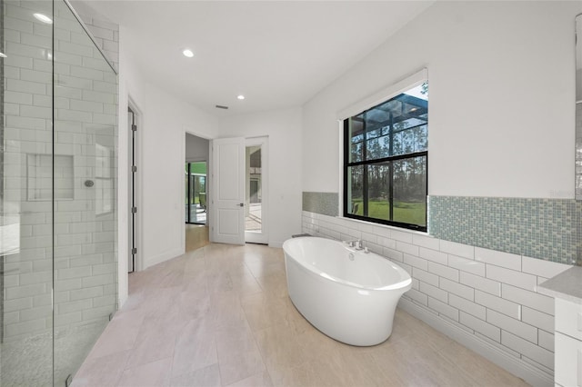 bathroom with independent shower and bath and tile walls