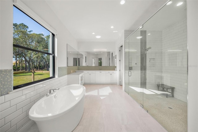 bathroom featuring tile patterned floors, vanity, tile walls, and independent shower and bath