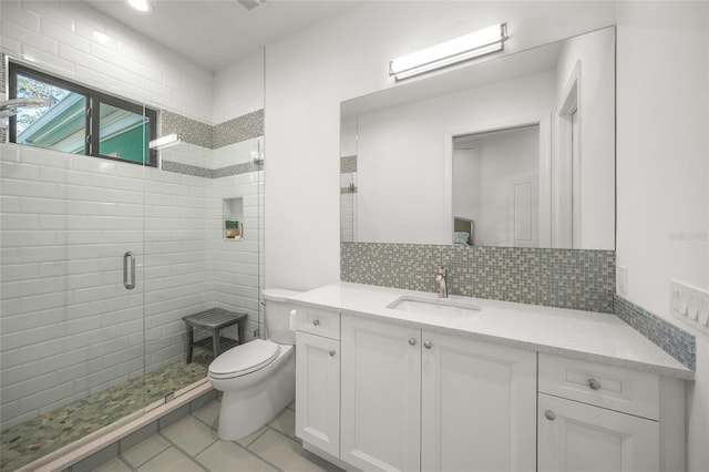 bathroom featuring tasteful backsplash, tile patterned floors, toilet, a shower with door, and vanity