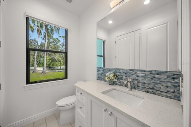 bathroom with tile patterned floors, vanity, toilet, and backsplash