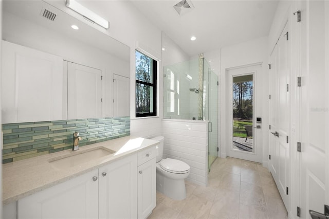 bathroom featuring vanity, tile patterned floors, decorative backsplash, toilet, and an enclosed shower