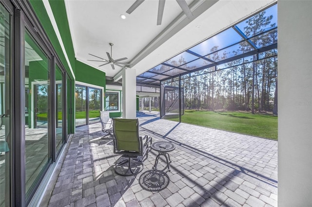 view of patio with glass enclosure and ceiling fan