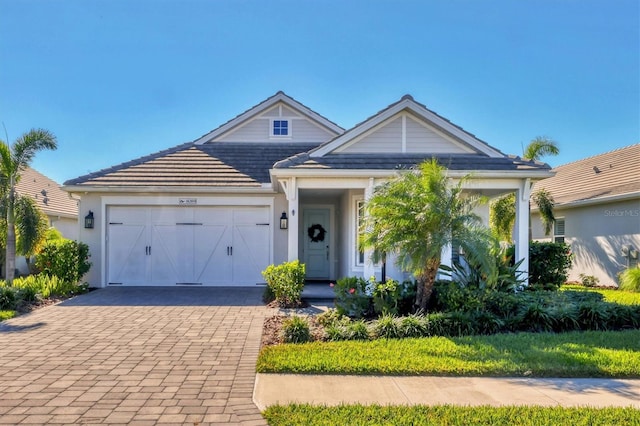 8089 Sandstar Way, Sarasota, FL 34240 - view of front of house featuring an attached garage and decorative driveway