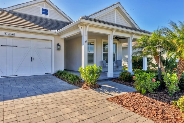 8089 Sandstar Way, Sarasota, FL 34240 - view of front facade featuring covered porch, a garage, stucco siding, decorative driveway, and ceiling fan