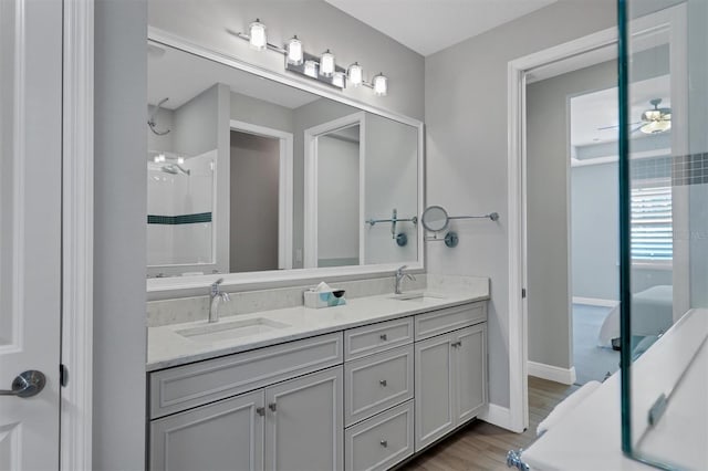 bathroom featuring walk in shower, wood-type flooring, vanity, and ceiling fan