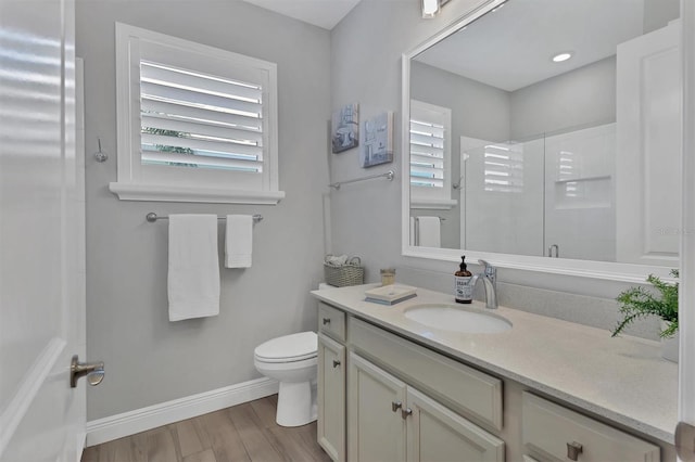 bathroom with vanity, hardwood / wood-style flooring, toilet, and walk in shower