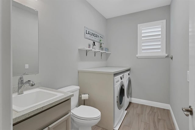 bathroom with vanity, washing machine and dryer, and toilet