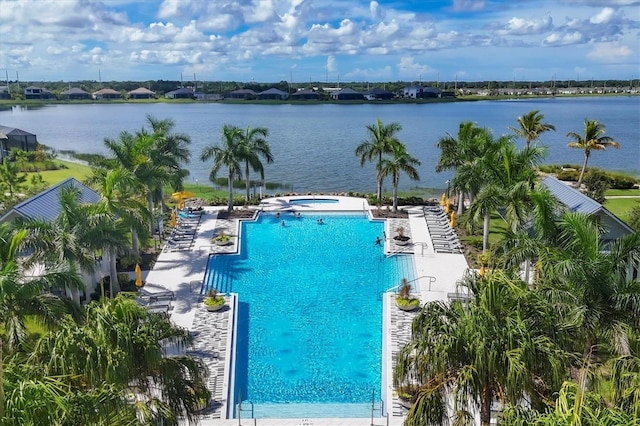 view of swimming pool featuring a water view and a patio