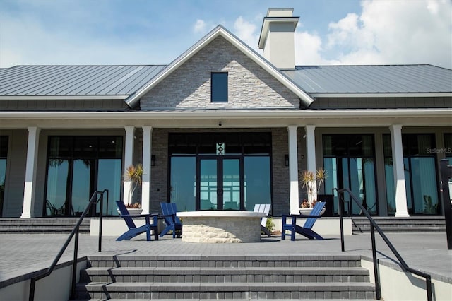 8089 Sandstar Way, Sarasota, FL 34240 - back of house with a porch, a chimney, a standing seam roof, and a metal roof