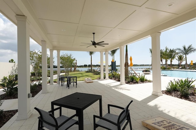 view of patio / terrace featuring a water view, ceiling fan, and a community pool