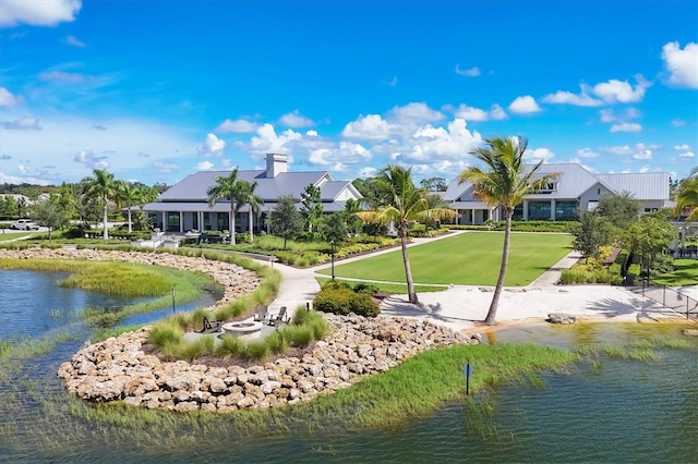 view of home's community with a lawn and a water view