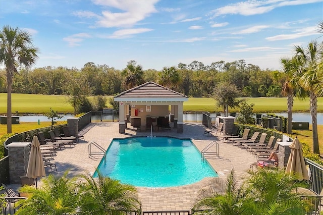 view of swimming pool with a water view and a patio area