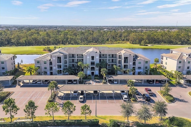 drone / aerial view of a large body of water, apartment complex / building, and a golf club