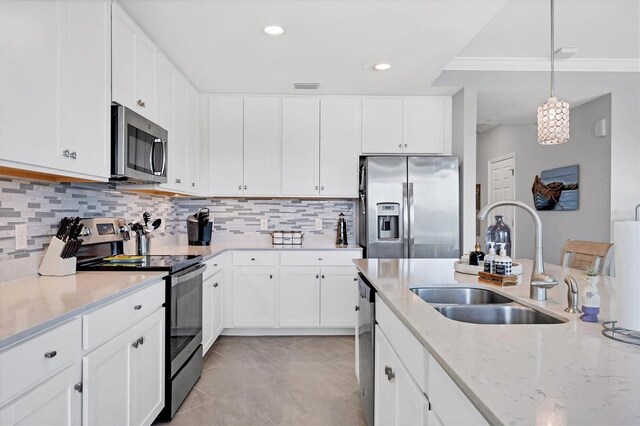 kitchen with appliances with stainless steel finishes, a sink, light stone counters, backsplash, and white cabinets