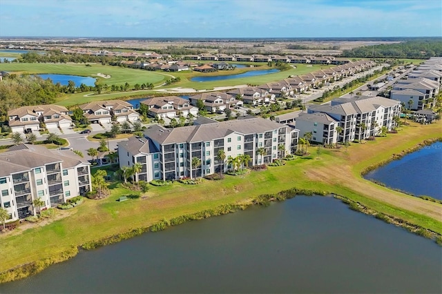 bird's eye view of apartment complex, a nearby body of water, and a local golf course