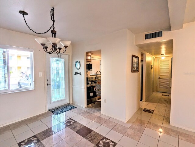 foyer with light tile patterned floors and a chandelier