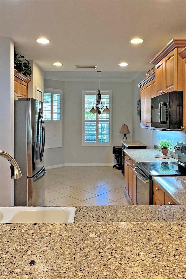 kitchen featuring light stone counters, a notable chandelier, decorative light fixtures, light tile patterned flooring, and appliances with stainless steel finishes